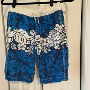Blue and white boys swim trunks. Tropical print.